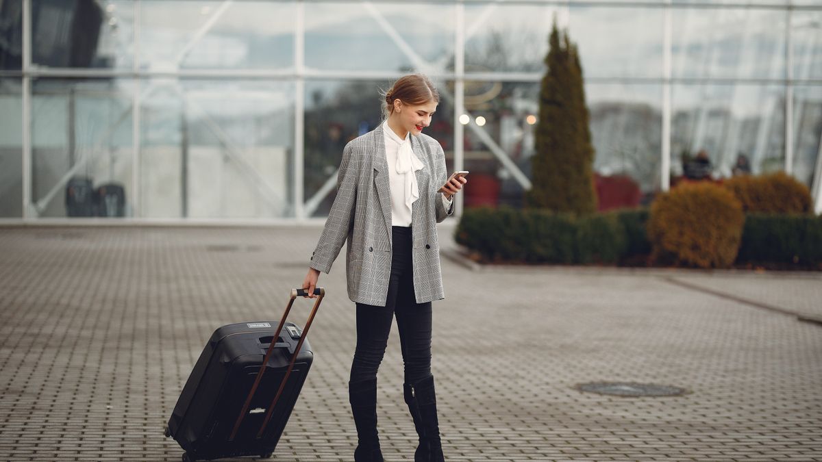 Traveller with a suitcase checking her phone