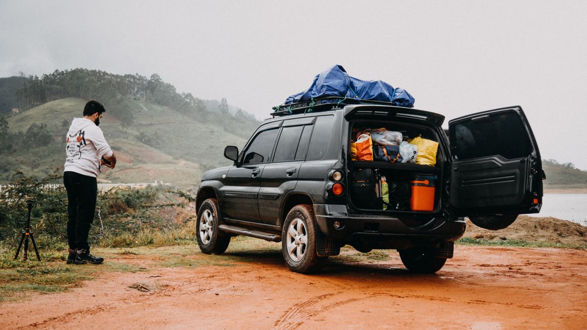 SUV au coffre ouvert chargé pour un road trip à la campagne