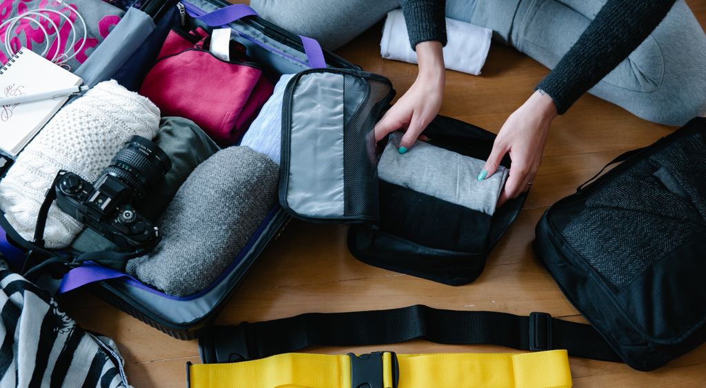 Hands placing a grey packing cube into a case