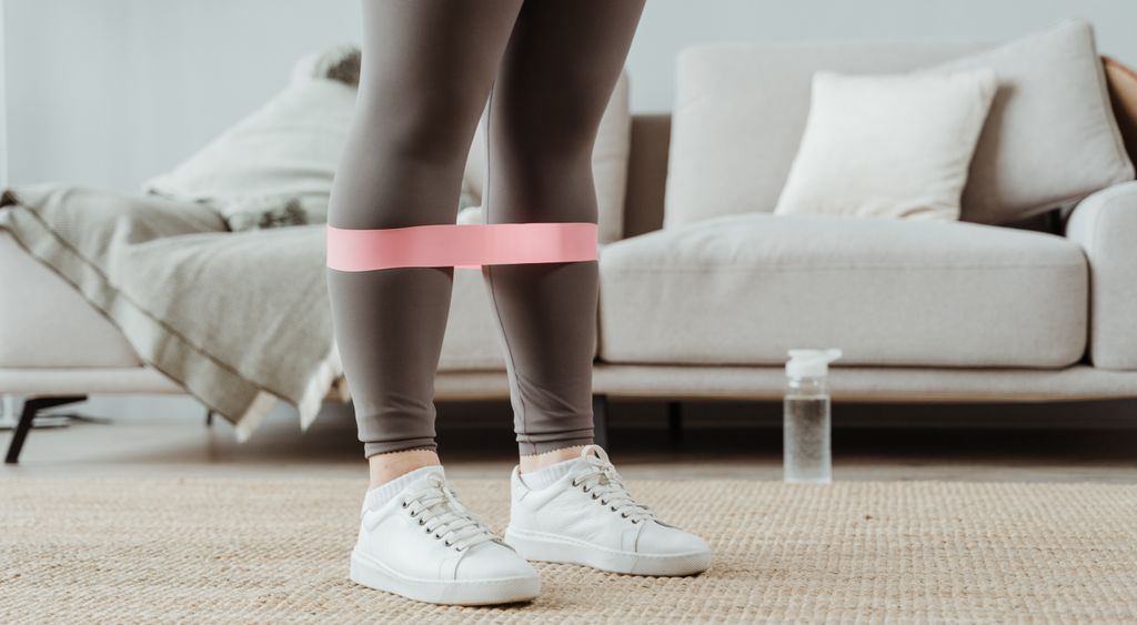 Loop resistance band around the legs during a home workout